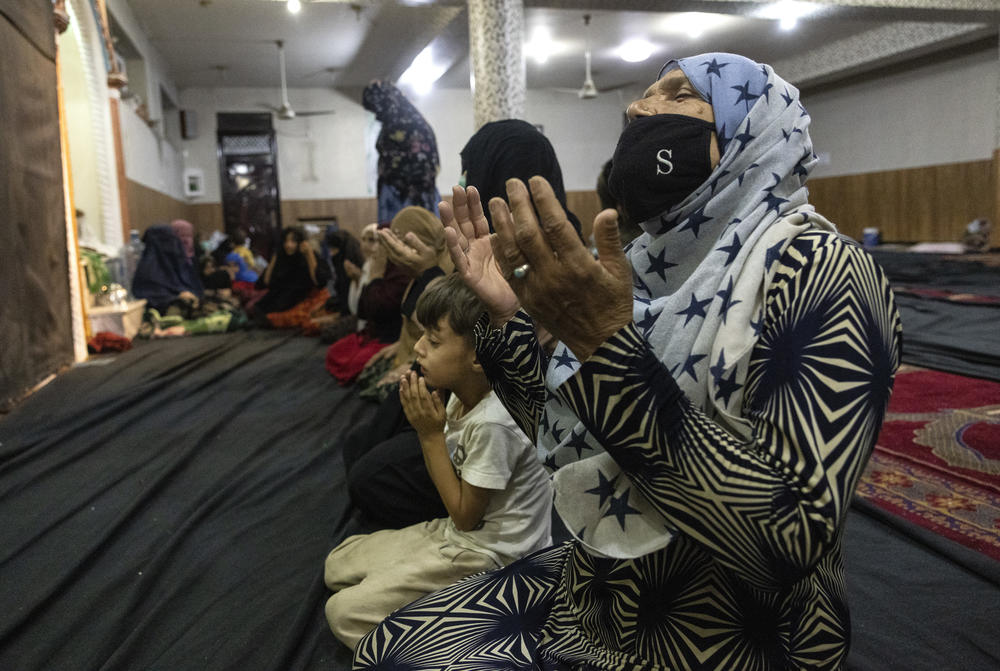 <strong>Fri., Aug. 13:</strong> Displaced Afghan women and children from Kunduz pray at a mosque that is sheltering them.
