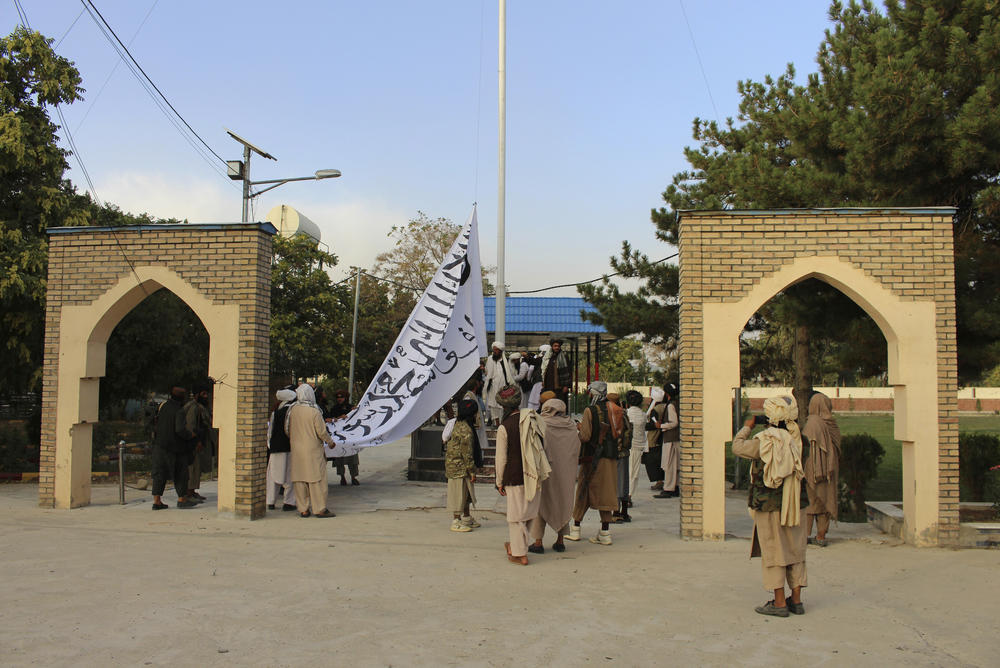 <strong>Sun., Aug. 15</strong>: Taliban fighters raise their flag at the Ghazni provincial governor's house, in Ghazni, southeastern, Afghanistan.