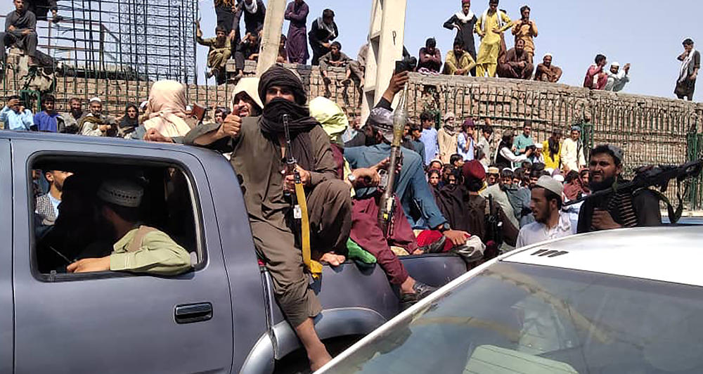 <strong>Sun., Aug. 15</strong>: Taliban fighters sit on a vehicle along the street in Jalalabad province on August 15, 2021.