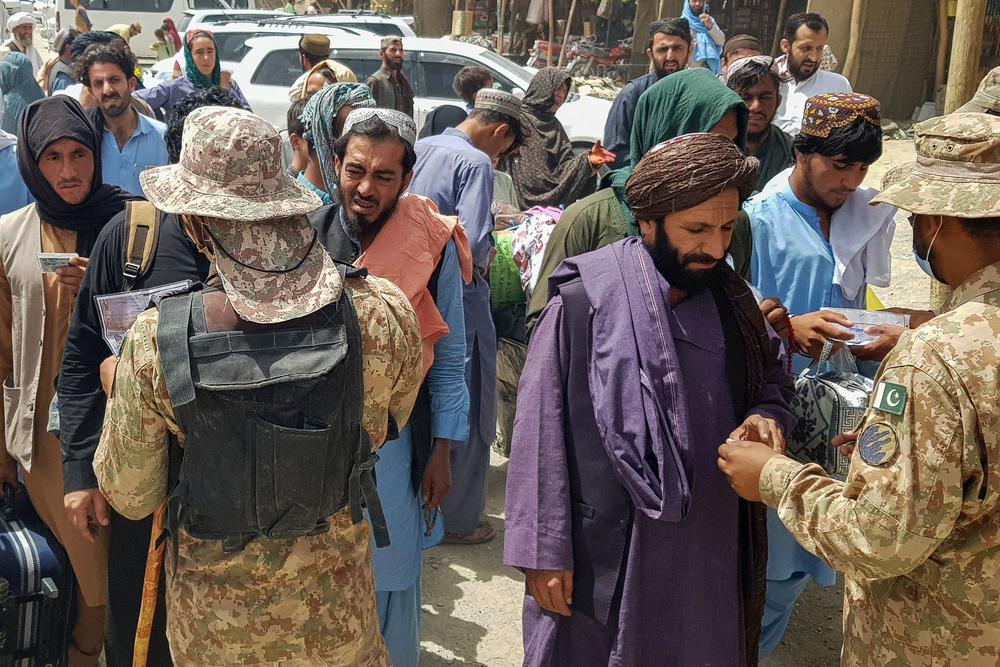 <strong>Sun., Aug. 15:</strong> Pakistani soldiers check the documents of stranded Afghan nationals wanting to return to Afghanistan at the Pakistan-Afghanistan border crossing point in Chaman.