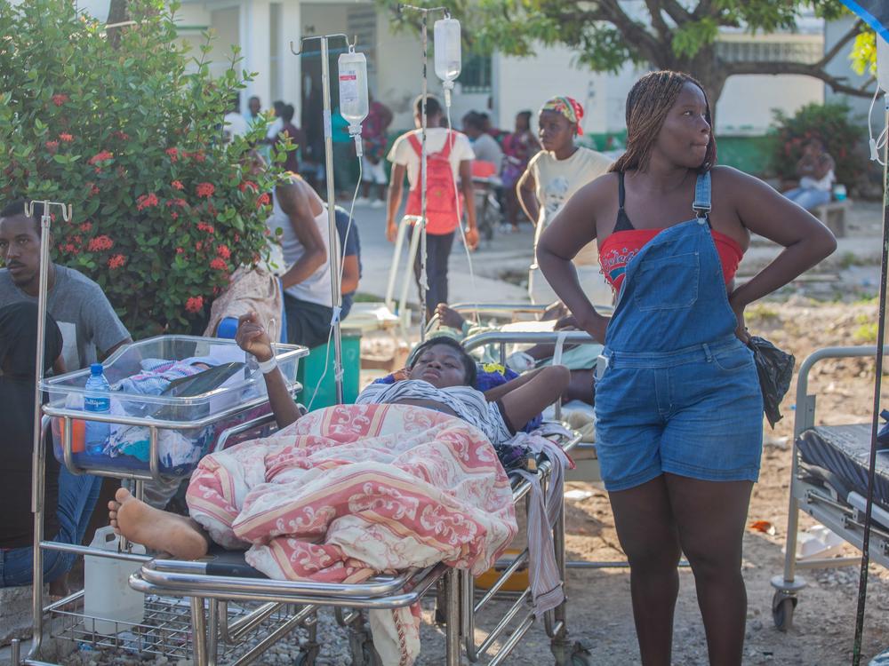 Patients are tended to Sunday outside Les Cayes General Hospital.