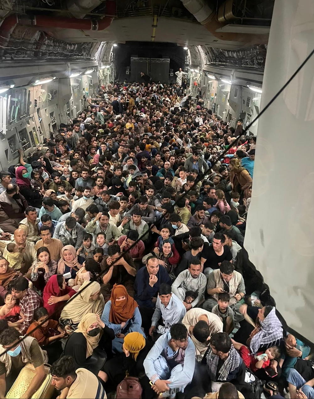 Evacuees crowd the interior of a U.S. Air Force C-17 Globemaster III transport aircraft, carrying some 640 Afghans to Qatar from Kabul on Sunday.