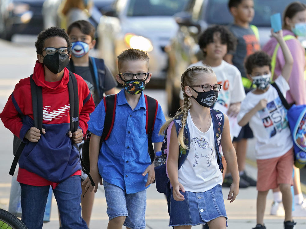 Students arrive for the first day of school on Aug. 10 at Sessums Elementary School in Hillsborough County, Fla. After thousands of students were put in isolation or quarantine, the district is revisiting its safety protocols, including its mask-optional policy.