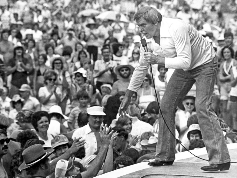 Singer Tom T. Hall leans to the edge of the stage at the Jamboree in the Hills near St. Clairsville, Ohio, in July 1977.