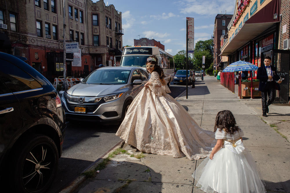 Citlaly Olvera Salazar holds up her gown as she walks towards her party bus.