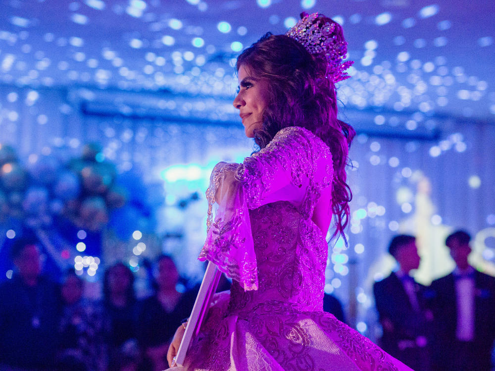 Citlaly Olvera Salazar dances with an image of her grandfather, Antonio Salazar, and father, Cesar Olvera, in their absence during her Quinceañera.