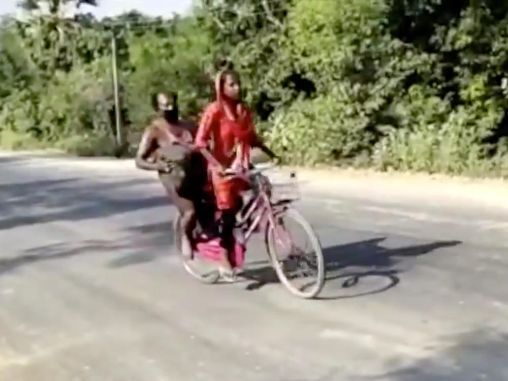 In this screen grab from video posted by BBC News Hindi, 15-year-old Jyoti Kumari rides with her father during their 700-mile journey to their family's village of Sirhulli in eastern India.