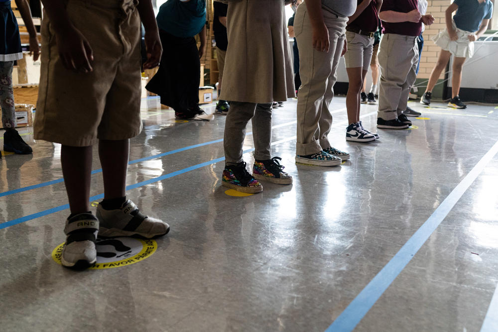 In order to keep them as separated as possible, students in Quesada's third grade class stand on carefully placed stickers on the floor. Because of the space instruments take up, and the need for students to be able to see their teacher, there's often only room for children to stand 3 feet apart, instead of 6.