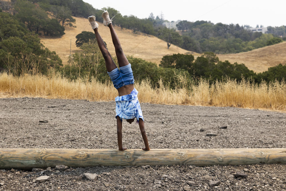 Josie, who is of Ethiopian descent, practices a handstand.