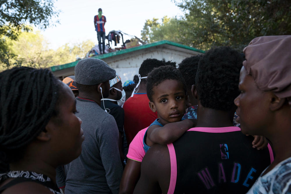 Migrants listen to Mexican immigration officers in a makeshift migrant camp.
