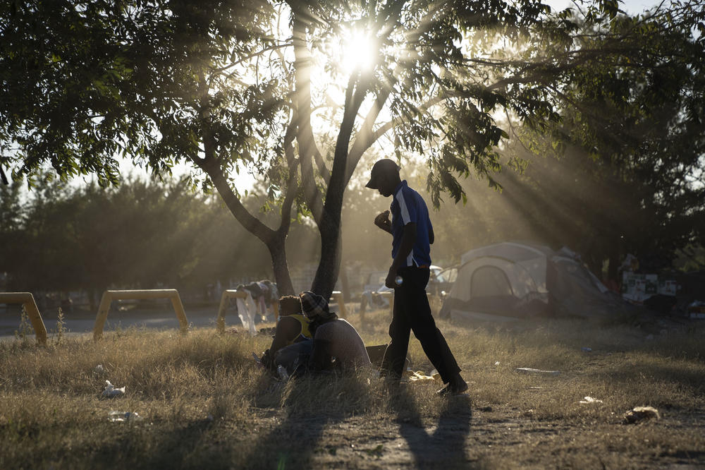 Migrants walk in a makeshift migrant camp.