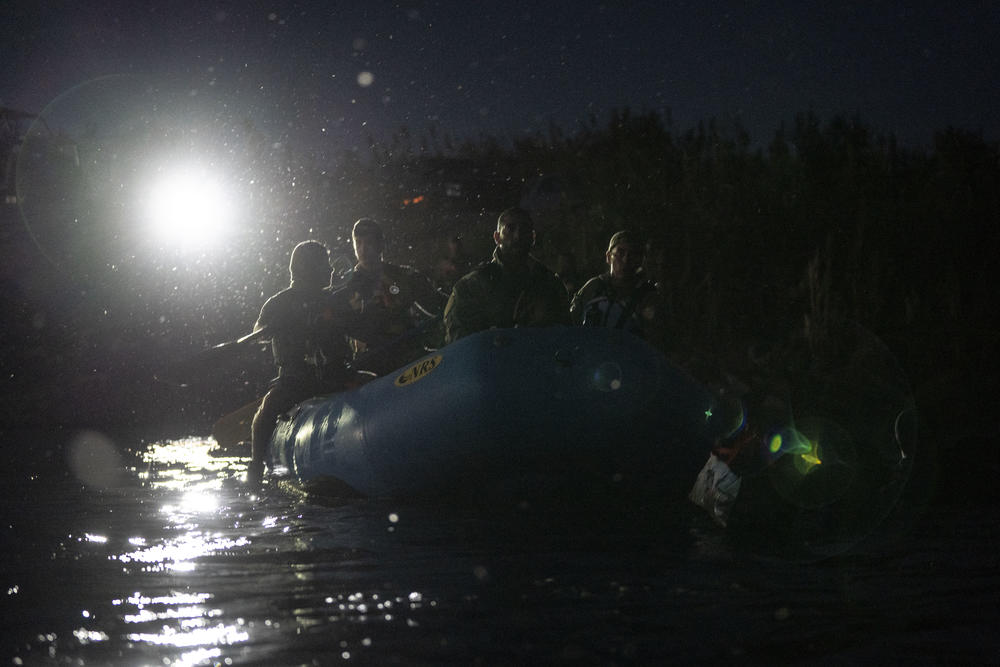 Custom Border Patrol agents search for migrants in the river.