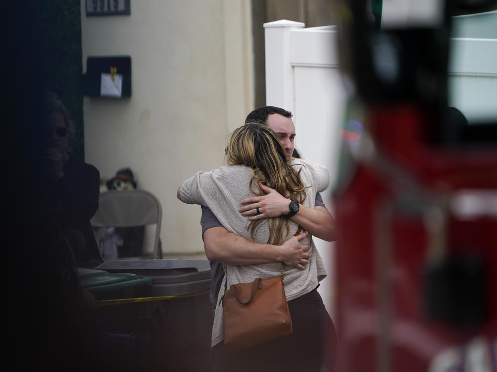 Two people embrace at the scene of the crash on Monday.