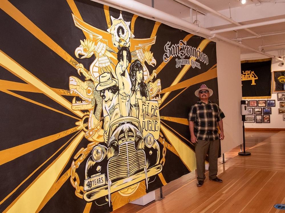 Roberto Y. Hernandez, founder and president of the San Francisco Lowrider Council, stands at the entrance to an exhibit about the council at the Mission Cultural Center for Latino Arts.