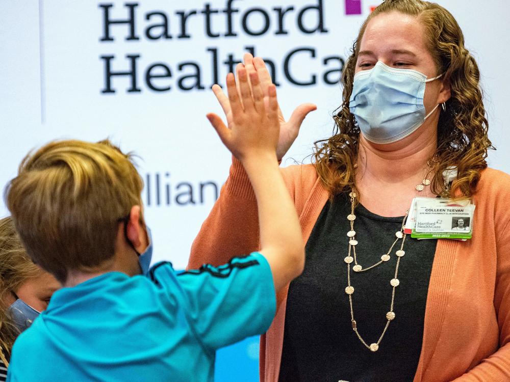 A 10-year-old high-fives pharmacist Colleen Teevan after he received the Pfizer-BioNTech COVID-19 vaccine for kids at Hartford Hospital in Hartford, Conn., on Tuesday.