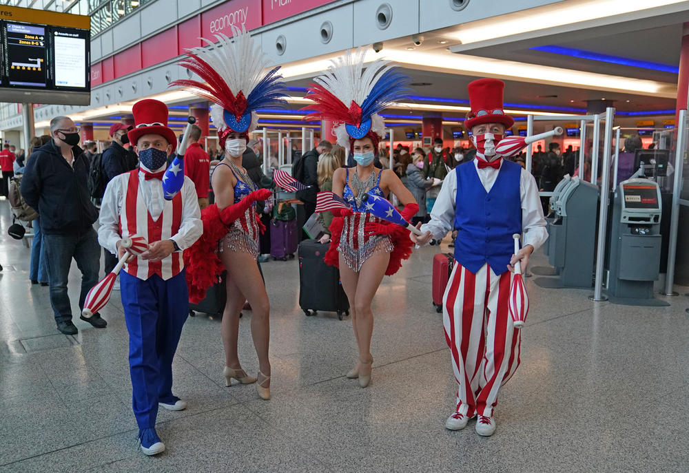 Performers entertain passengers at London Heathrow Airport's T3 as the U.S. reopens its borders to UK visitors in a significant boost to the travel sector.