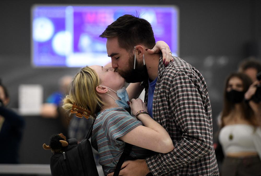 A couple embrace each other as they are reunited upon her arrival on a flight from Frankfurt, Germany.