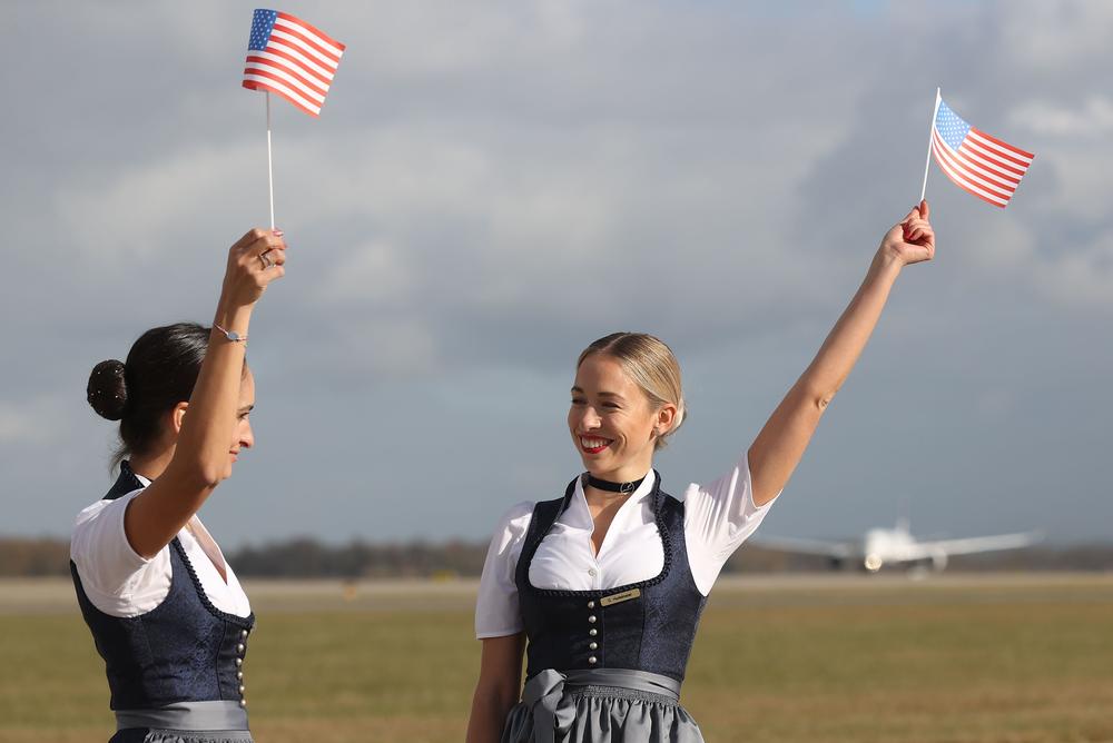 A Lufthansa Crew in traditional Bavarian costume wave to an Lufthansa Airbus A 350-900 prior to a flight bound non-stop for Miami at Munich Airport on the first day that U.S. authorities are allowing tourists from Europe to enter the U.S.