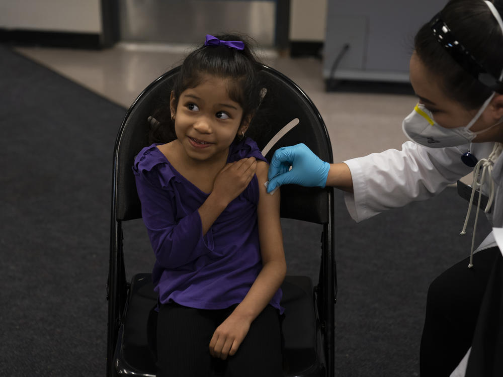 Elsa Estrada, 6, smiles at her mother before receiving the Pfizer-BioNTech COVID-19 vaccine on Tuesday at a pediatric vaccine clinic for children at Willard Intermediate School in Santa Ana, Calif.