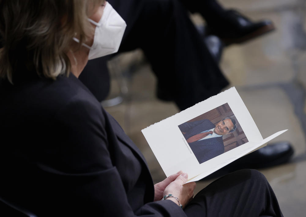 A mourner holds a program showing former Sen. Bob Dole, prior to a congressional ceremony to honor Dole, in the U.S. Capitol Rotunda on Dec. 9, 2021 in Washington, D.C. The former Senate Majority Leader and GOP presidential nominee, will lie in state in the Capitol Rotunda on Thursday before being taken to the National Cathedral for a funeral service on Friday.