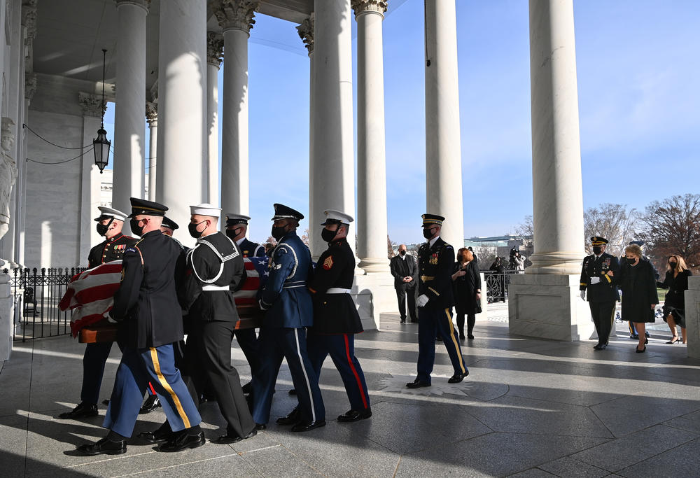 A joint services military honor guard carries the casket containing the remains of the late Sen. Bob Dole into the U.S. Capitol where he will lie in state on December 9, 2021 in Washington, D.C. Following the casket are Chairman of the Joint Chiefs of Staff Gen. Mark Milley; Dole's wife, former Sen. Elizabeth Dole; and daughter, Robin.