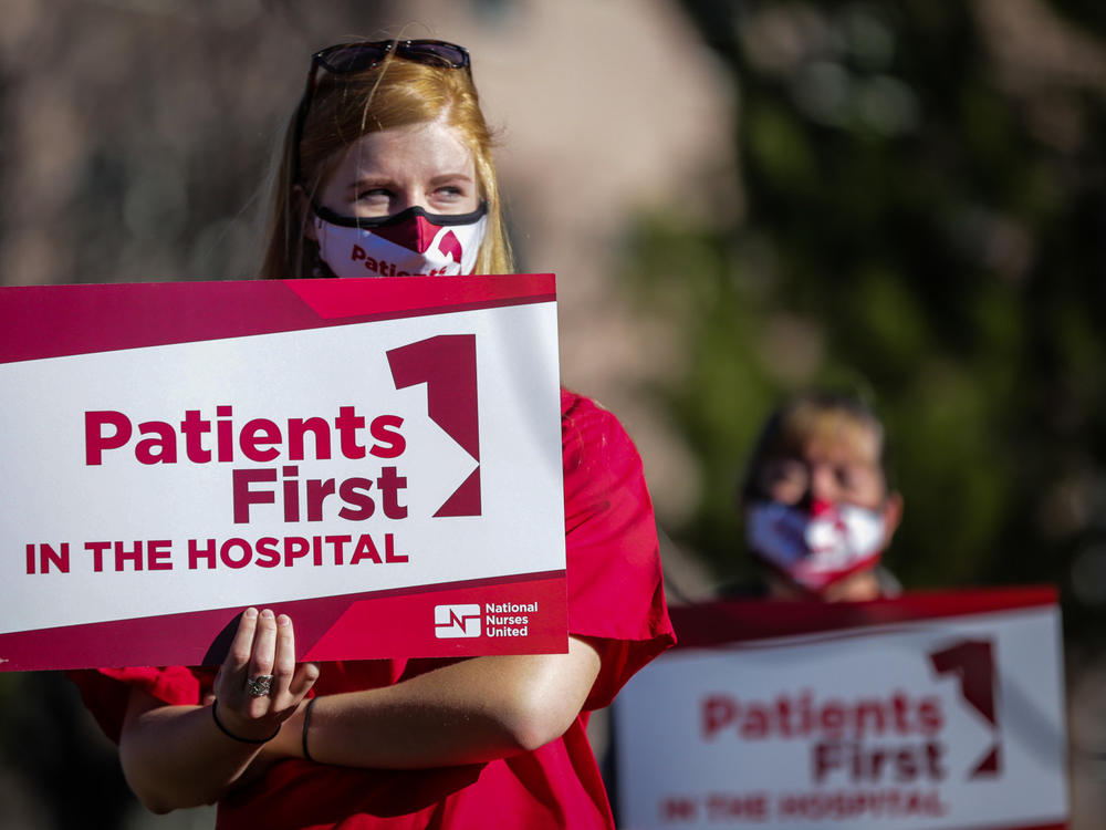 Longmont United Hospital nurse Brooke Schroeder holds a sign supporting nurses December 2, 2021. Nurses say the hospital is severely understaffed and they're trying to form a union.