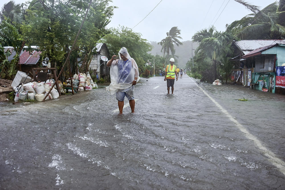 Residents of Pagnamitan, Guiuan, Eastern Samar, eastern Philippines wade through a flooded road caused by Typhoon Rai on Thursday, Dec. 16, 2021.