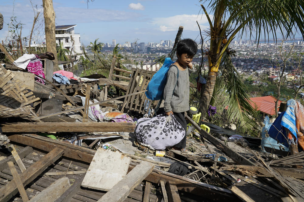 Romel Lo-ang recovers personal belongings from their damaged home due to Typhoon Rai in Cebu province, central Philippines on Sunday Dec. 19, 2021.
