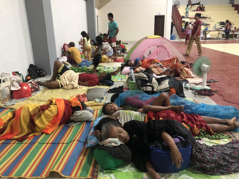 In this photo taken early December 16, 2021, residents sleep inside a sports complex turned into an evacuation center in Dapa town, Siargao island, Surigao del Norte province in southern island of Mindanao, ahead of Typhoon Rai's landfall in the province.