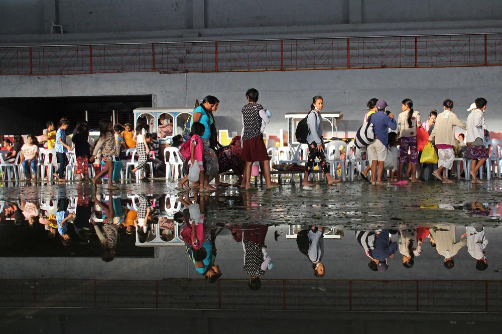 Residents take shelter in a cultural center turned into an evacuation center after Super Typhoon Rai passed in Isabela town of Negros Occidental province on December 17, 2021.
