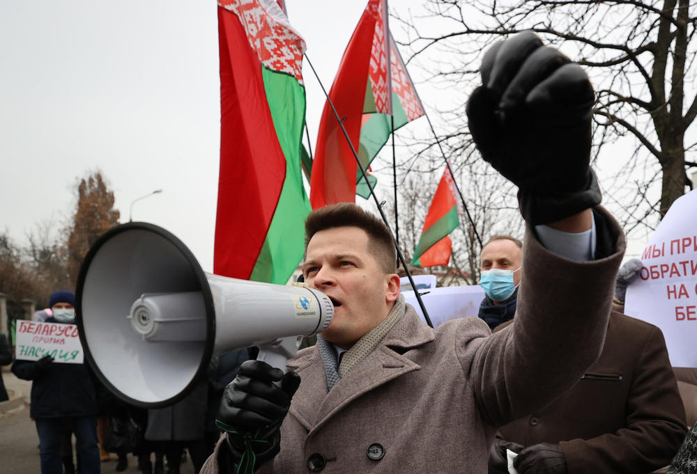 A man uses a loud-hailer during a rally held outside the Minsk office of the U.N. High Commissioner for Refugees to condemn what he considered global institutions' inaction in the face of a migrant crisis on the Belarusian-Polish border.