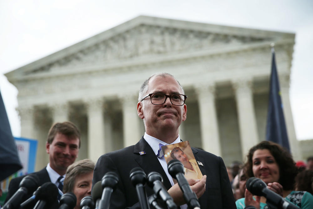 Plaintiff Jim Obergefell holds a photo of his late husband John Arthur as he speaks to members of the media after the U.S. Supreme Court handed down a ruling in favor of same-sex marriage rights on June 26, 2015 outside the court in Washington, D.C.