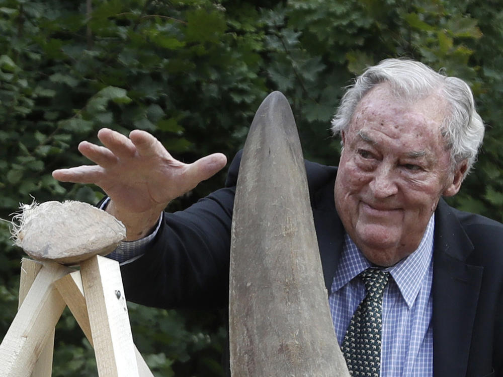 Richard Leakey, Kenyan wildlife conservationist, places a rhino horn to be burned at the zoo in Dvur Kralove, Czech Republic, in 2017. Leakey, known for his fossil-finding and conservation work in his native Kenya, has died at 77.