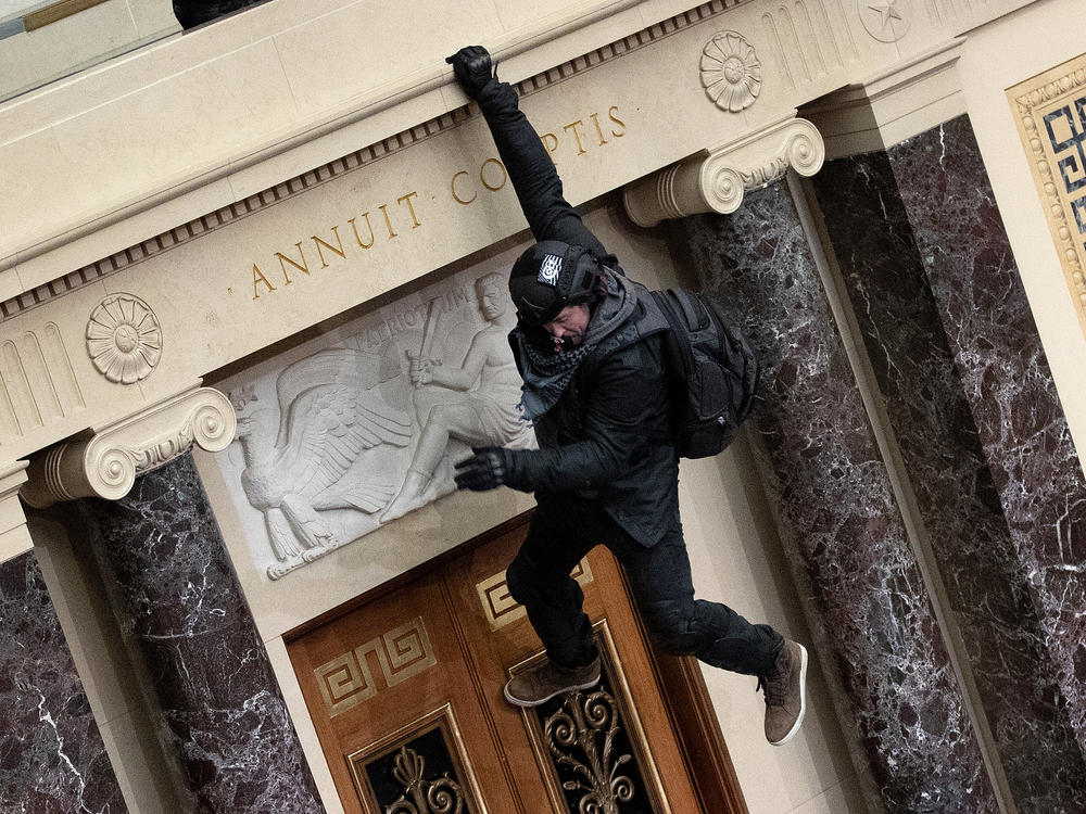 A protester supporting then-President Donald Trump jumps from the public gallery to the floor of the Senate chamber at the U.S. Capitol on Jan. 6, 2021.