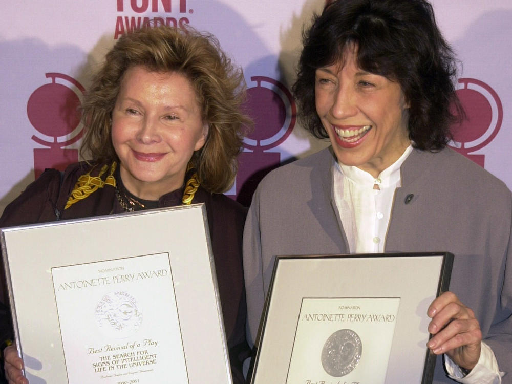 Jane Wagner (L) and Lily Tomlin hold up the Tony Award nominations they earned as producers of <em>The Search for Signs of Intelligent Life in the Universe</em> in 2001.