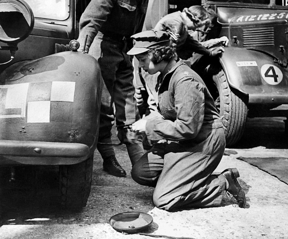 <strong>Circa 1940s:</strong> Princess Elizabeth changes the wheel of a military vehicle during World War II.