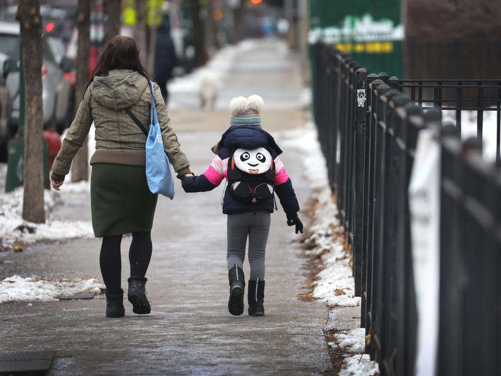A student arrives for classes at a Chicago elementary school on January 12, 2022.