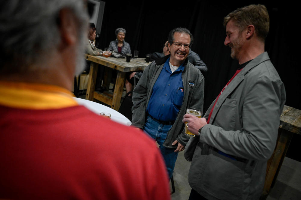 Emilio Valdez (center) speaks with congressional candidate Erik Aadland at Rails End Beer Co. on Jan. 28. Valdez, a Republican voter, said he likes to know what candidates stand for before signing petitions in support of them.