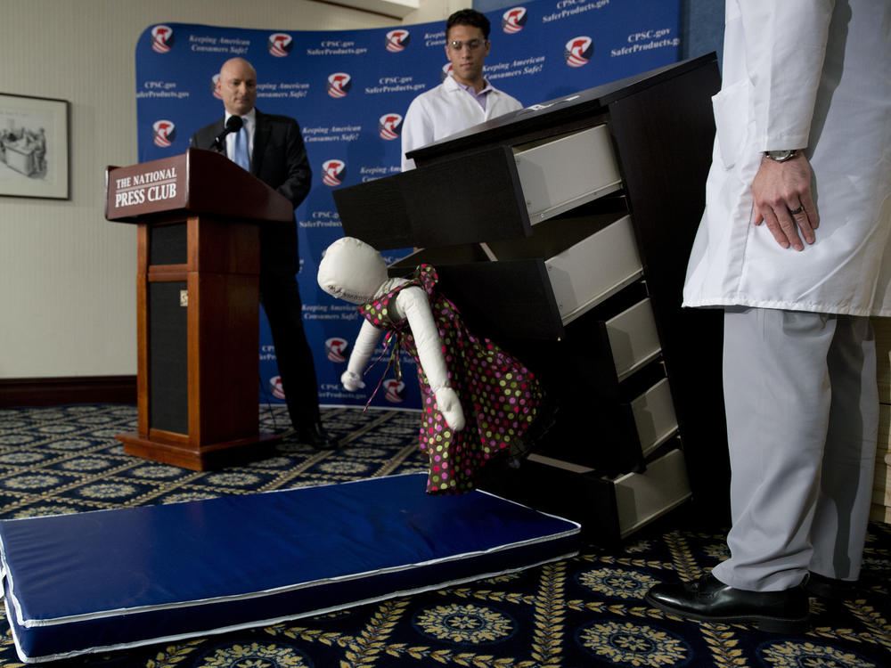 Elliot Kaye (left), then chairman of the Consumer Product Safety Commission, watches a demonstration of how an Ikea dresser can tip and fall on a child during a news conference at the National Press Club in 2016.