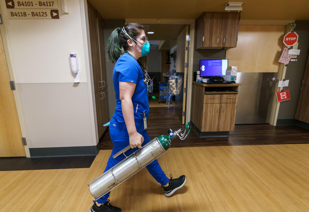 Nurse Danielle LaRocco carries an oxygen tank to the room of a COVID-19 patient on an acute-care floor at Salem Health on Jan. 27.