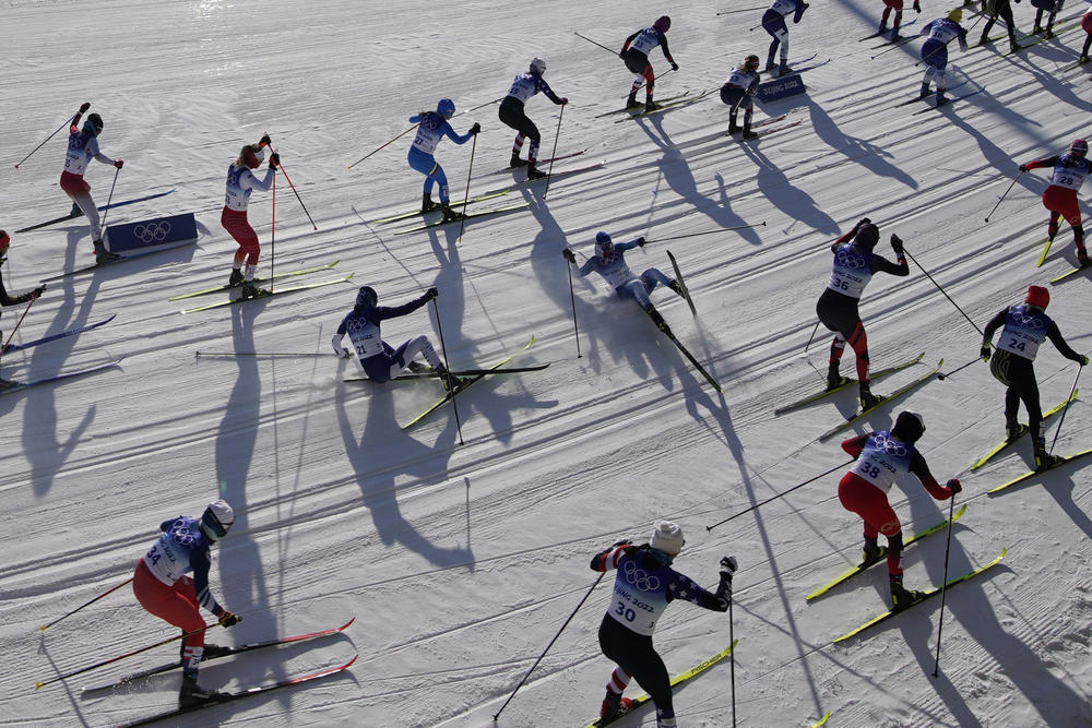 Skiers fall while competing during the women's 7.5km + 7.5km Skiathlon cross-country skiing competition at the 2022 Winter Olympics, Saturday, Feb. 5, 2022, in Zhangjiakou, China.