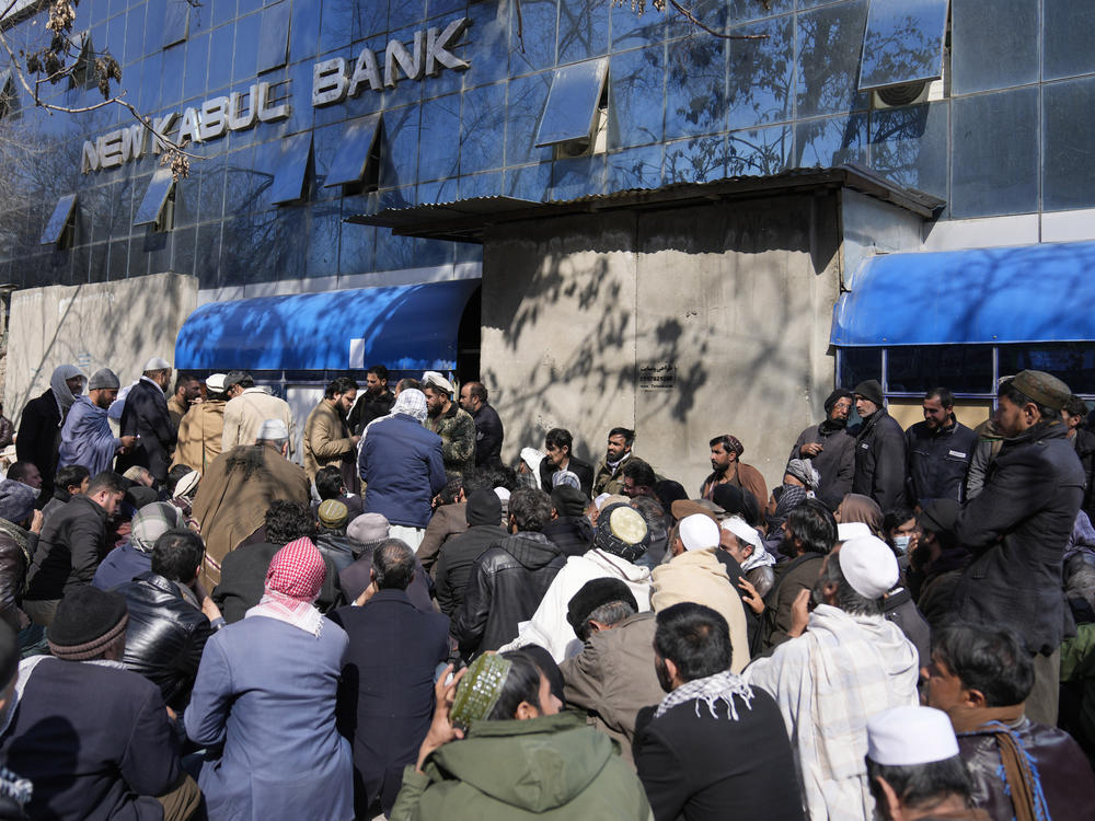 Afghan wait to enter a bank, in Kabul, Afghanistan, Sunday, Feb. 13, 2022.