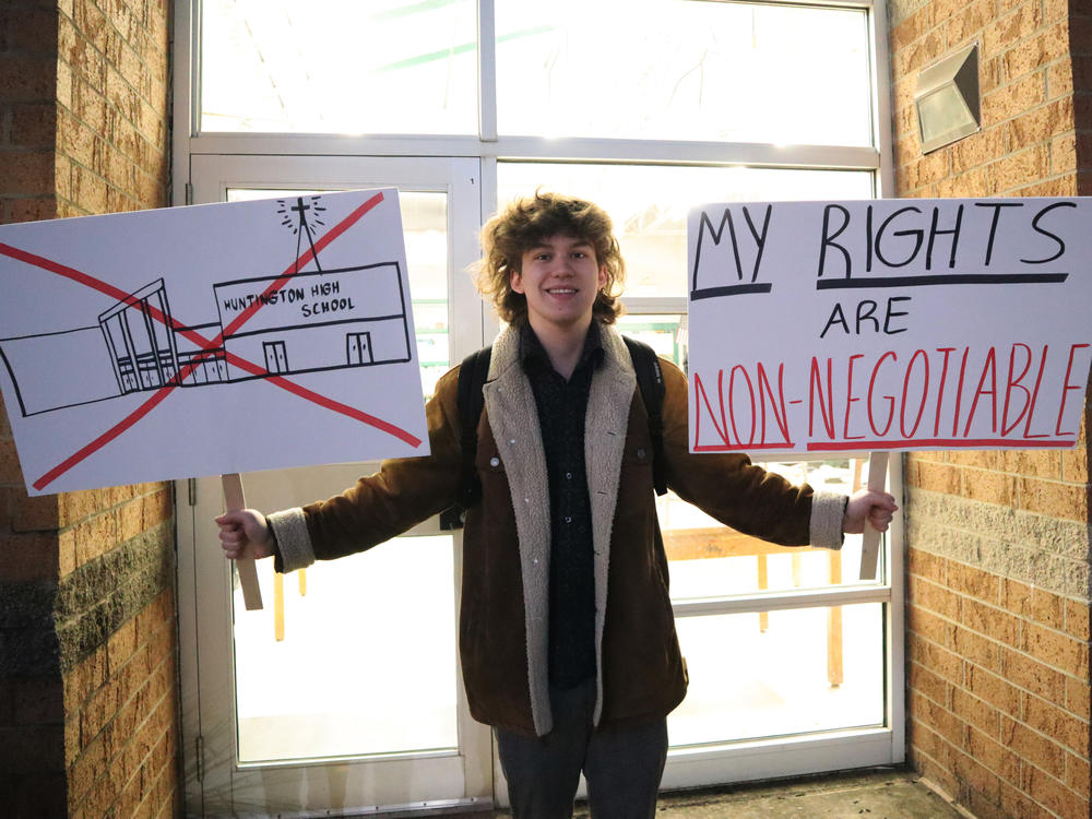 Huntington High School senior Max Nibert holds signs he plans to use during a student walkout at the school in Huntington, W.Va., on Feb. 9. Now, families are suing the school district, alleging it violated students' religious freedoms.