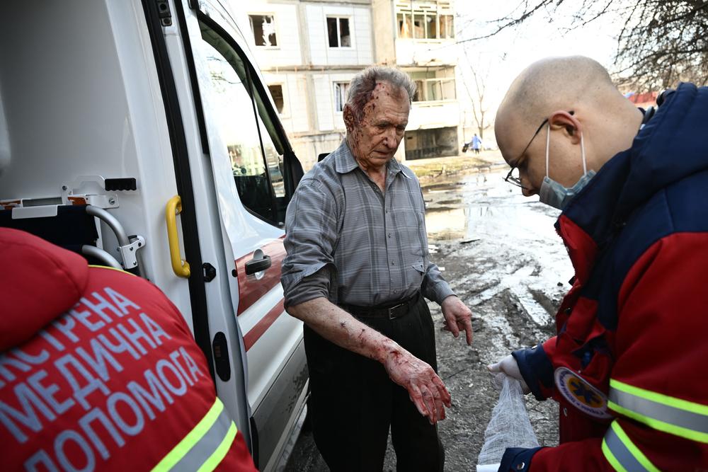 Emergency unit staff treat an injured man after bombings on the eastern Ukraine town of Chuhuiv on Feb. 24.
