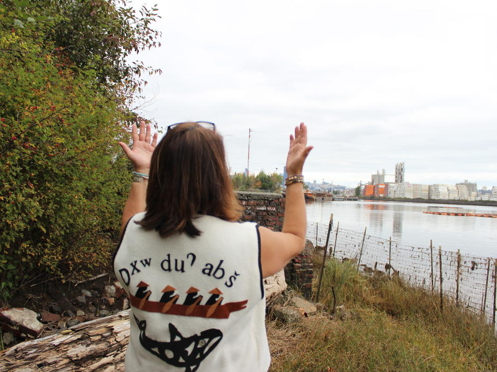 Duwamish Tribal Services Executive Director Jolene Haas holds up her hands, a traditional gesture of gratitude, on the banks of the Duwamish River in Seattle on Sept. 21, 2019.