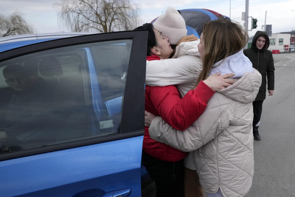A woman hugs another women upon her arrival at the border crossing in Medyka, southeastern Poland, from neighboring Ukraine on Friday, Feb. 25, 2022.