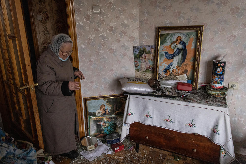 A resident checks on a damaged room of her apartment in a residential block hit by an early morning missile strike on February 25, 2022 in Kyiv, Ukraine.