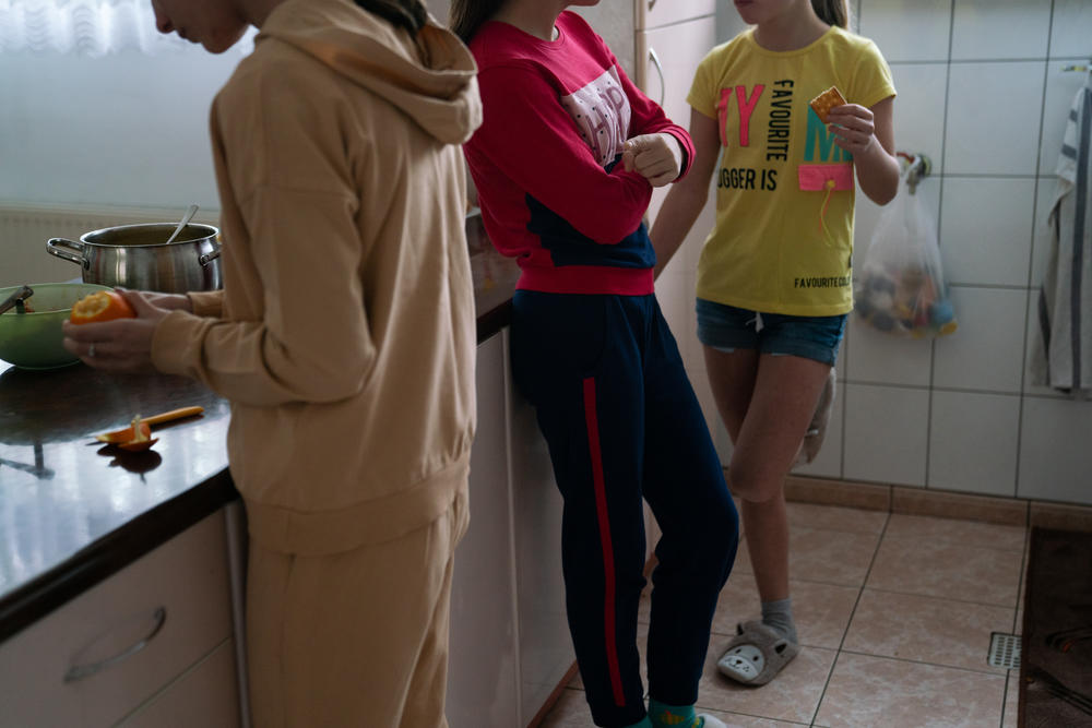 Three Ukrainian girls hang out in the kitchen of their new foster home in Poland.