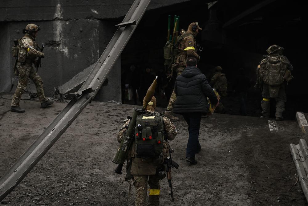 <strong>March 5:</strong> Ukrainian servicemen walk through a destroyed bridge towards the city of Irpin, northwest of Kyiv, during heavy shelling and bombing.