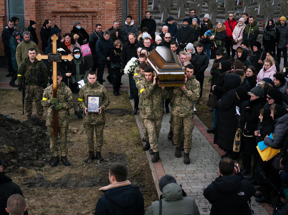 Tuesday's funeral procession ends at the gravesites where soldiers Viktor Dudar, 44, and Ivan Koverznev, 24, will be buried as priests say their blessings and mourners look on.